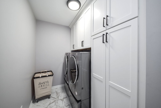 laundry area featuring separate washer and dryer and cabinets