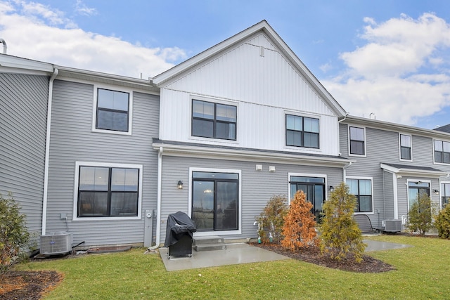 rear view of house featuring central AC unit, a patio, and a lawn