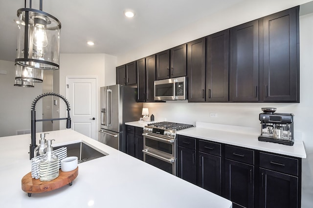 kitchen featuring appliances with stainless steel finishes, sink, and decorative light fixtures