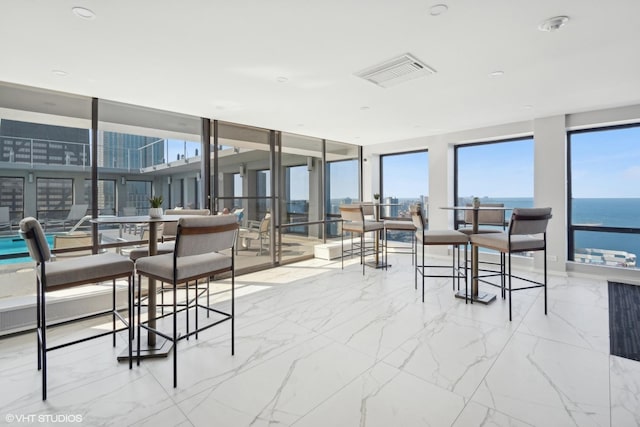 sunroom featuring a water view