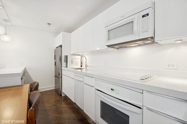 kitchen with pendant lighting, sink, white appliances, and white cabinets