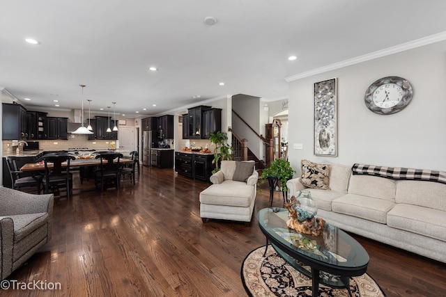 living room with crown molding, dark wood-type flooring, and sink