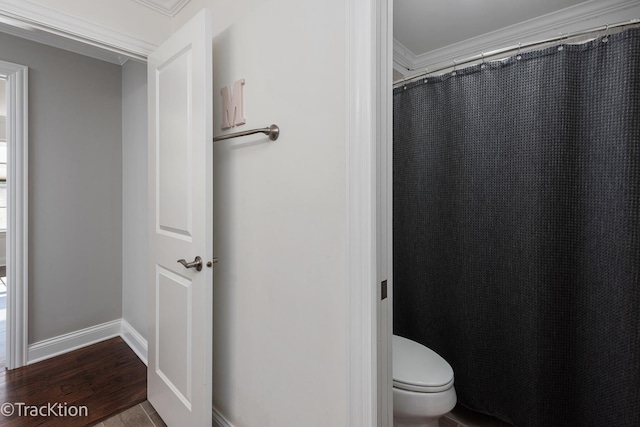 bathroom featuring ornamental molding, hardwood / wood-style floors, and toilet