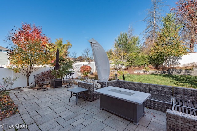 view of patio with an outdoor living space with a fire pit