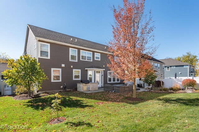 back of property with a yard and a patio