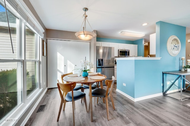 dining space with plenty of natural light and light wood-type flooring