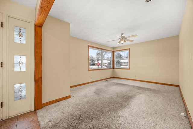 interior space with a textured ceiling, light colored carpet, and ceiling fan