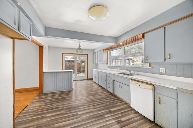 kitchen with dark hardwood / wood-style flooring, sink, backsplash, and white dishwasher