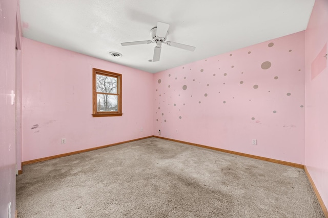 empty room featuring ceiling fan and carpet