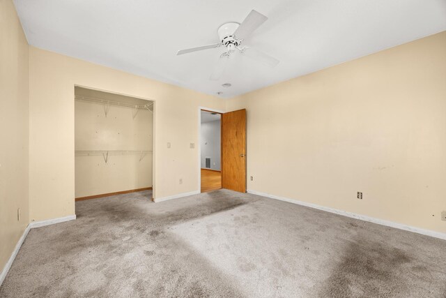 spare room featuring lofted ceiling with skylight, carpet, and ceiling fan