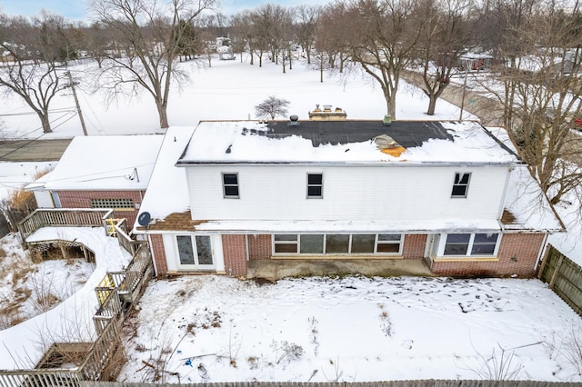 view of snow covered back of property