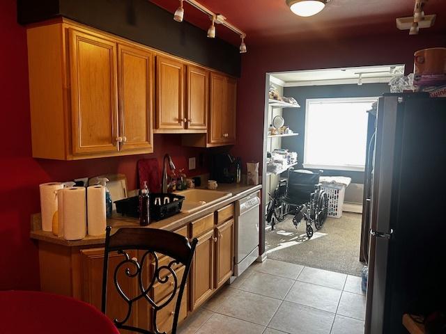 kitchen with stainless steel fridge, dishwasher, sink, and light tile patterned floors