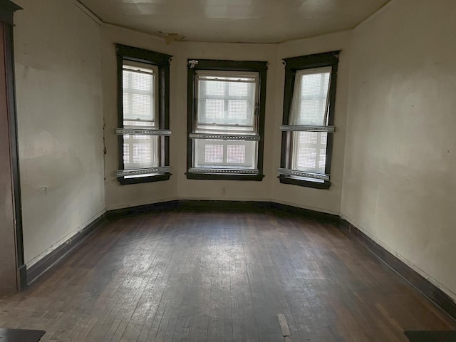 empty room with dark wood finished floors and baseboards