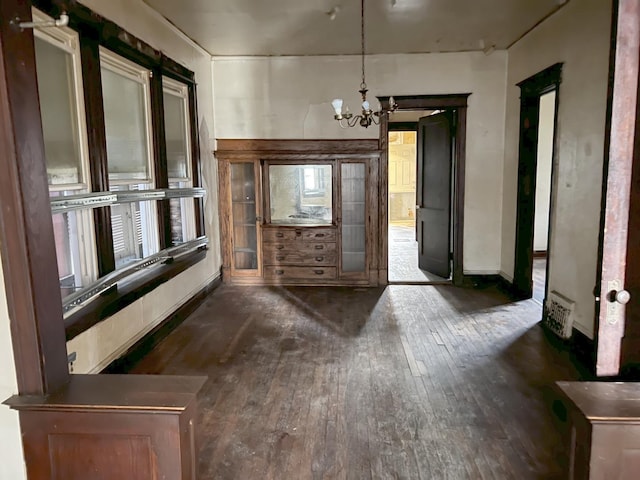 interior space featuring hardwood / wood-style flooring, baseboards, and a chandelier