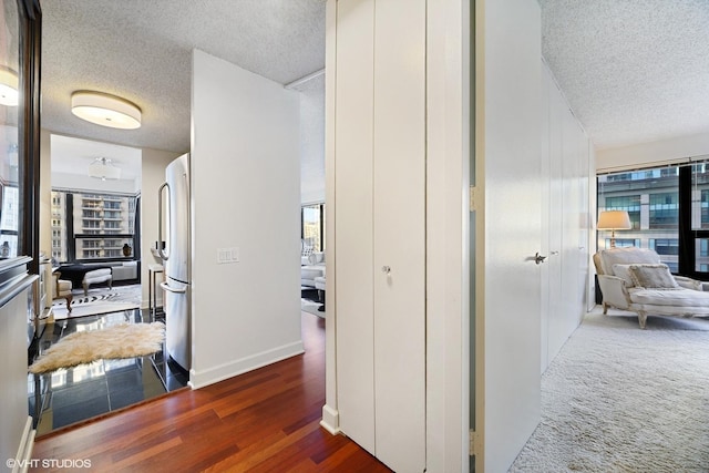 hall with dark wood-type flooring and a textured ceiling