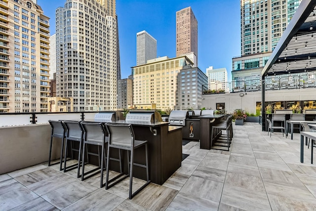 view of patio / terrace with grilling area, exterior kitchen, and an outdoor bar