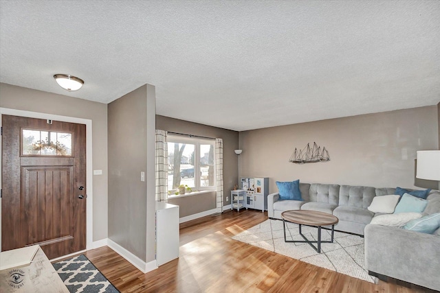 foyer entrance with a textured ceiling and light wood-type flooring