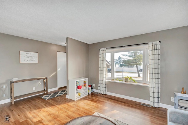 living area featuring hardwood / wood-style flooring and a textured ceiling