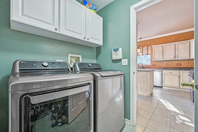 washroom featuring light tile patterned floors, crown molding, sink, cabinets, and separate washer and dryer