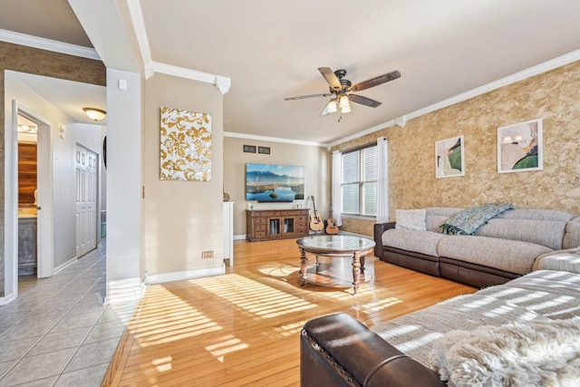 living room featuring ceiling fan, ornamental molding, and light wood-type flooring