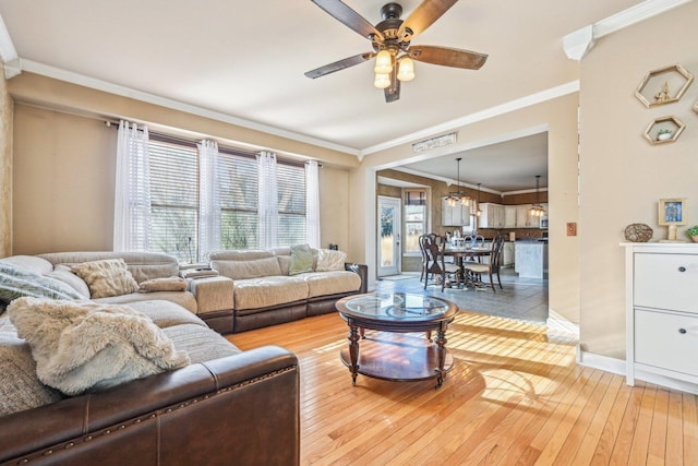 living room featuring crown molding, ceiling fan, and light hardwood / wood-style floors