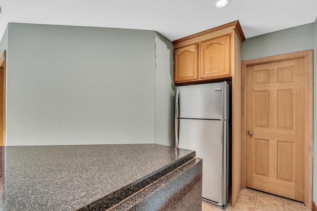 kitchen featuring light tile patterned floors and stainless steel refrigerator