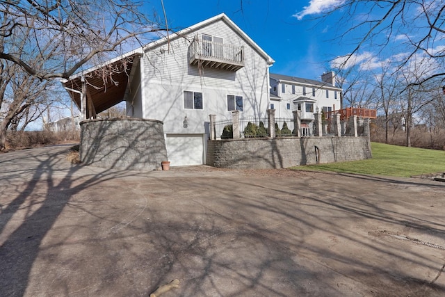 exterior space featuring a garage and a balcony