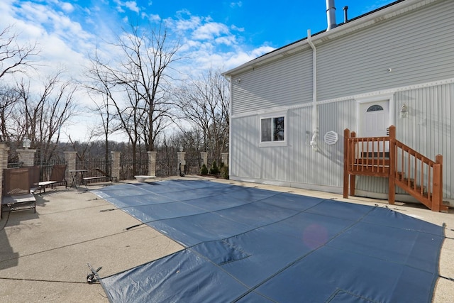 view of swimming pool with a patio and a diving board