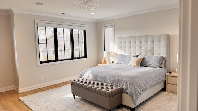 bedroom with light wood-style floors, visible vents, baseboards, and crown molding