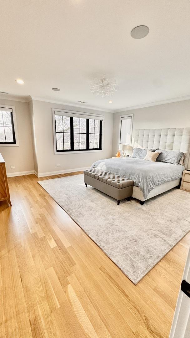 bedroom with light wood-style floors, recessed lighting, ornamental molding, and baseboards