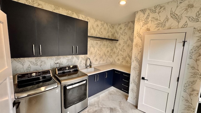 laundry area with recessed lighting, a sink, cabinet space, washer and clothes dryer, and wallpapered walls