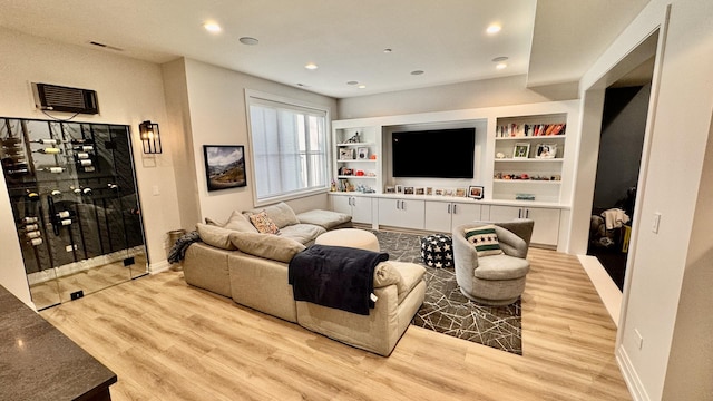 living area with built in shelves, recessed lighting, wood finished floors, and baseboards