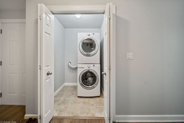 laundry area featuring stacked washer / dryer and light hardwood / wood-style floors