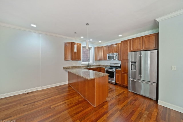 kitchen with hanging light fixtures, stainless steel appliances, light stone counters, ornamental molding, and kitchen peninsula