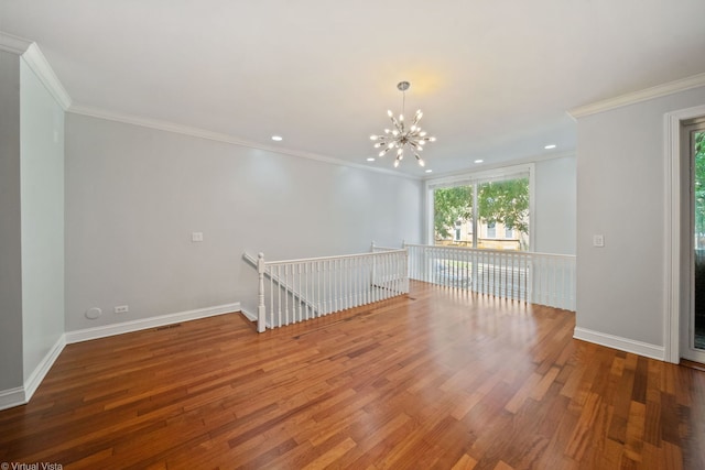 unfurnished room featuring crown molding, a healthy amount of sunlight, hardwood / wood-style floors, and a notable chandelier