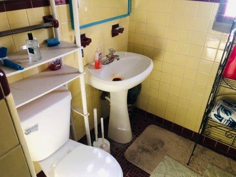 bathroom featuring tile walls, tile patterned floors, and toilet