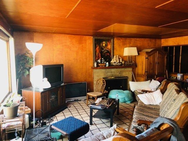 living room with wood ceiling and wood walls