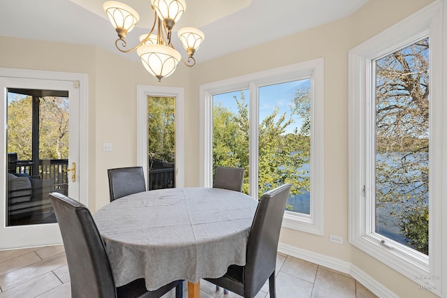 dining room with an inviting chandelier, light tile patterned floors, and plenty of natural light