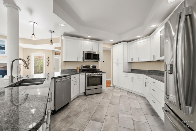 kitchen featuring white cabinetry, stainless steel appliances, decorative light fixtures, and sink