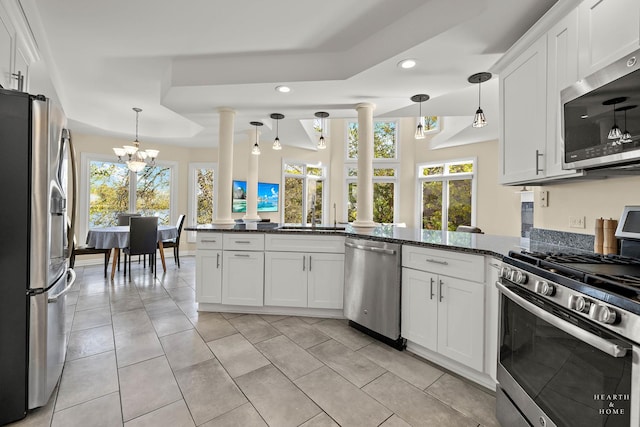 kitchen featuring pendant lighting, dark stone counters, white cabinets, and appliances with stainless steel finishes