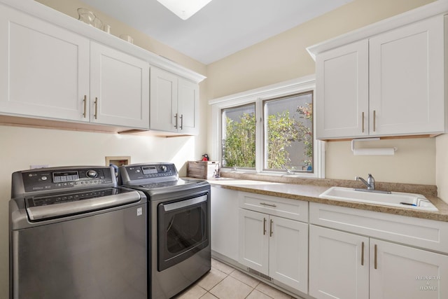 laundry room with cabinets, sink, washing machine and dryer, and light tile patterned floors