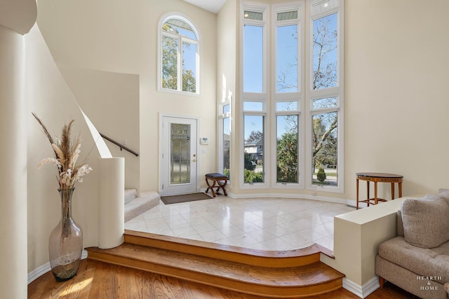 foyer entrance featuring a towering ceiling and tile patterned floors