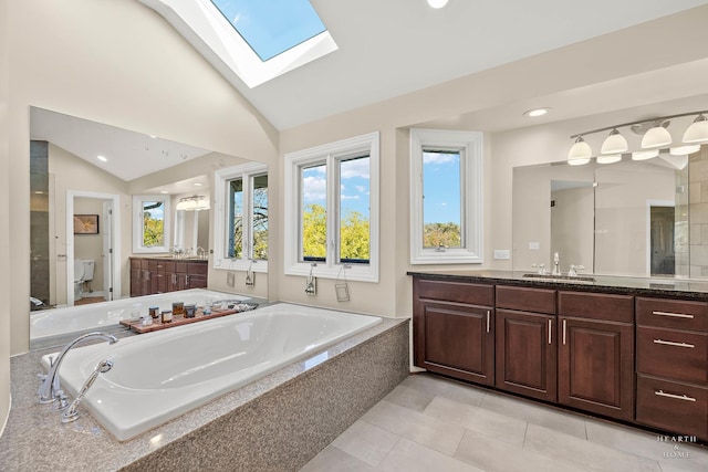 bathroom featuring tile patterned flooring, lofted ceiling with skylight, vanity, and toilet