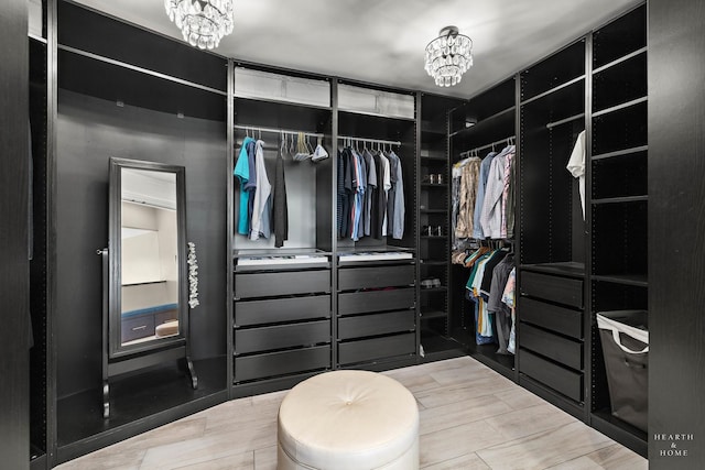 spacious closet with a notable chandelier and hardwood / wood-style flooring