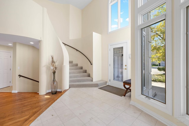 entryway with light hardwood / wood-style flooring and a high ceiling