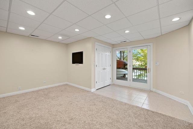 carpeted spare room featuring a paneled ceiling