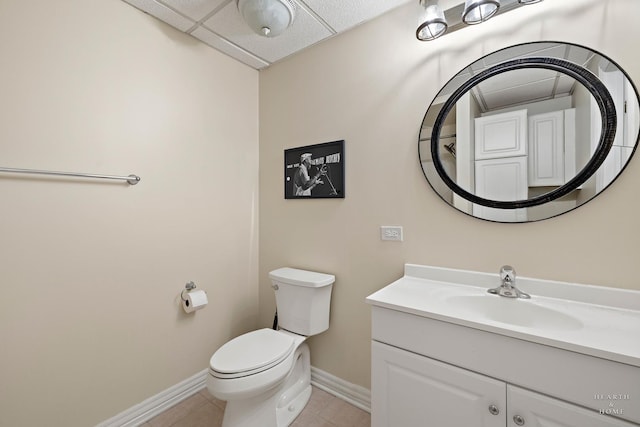 bathroom featuring vanity, tile patterned flooring, a paneled ceiling, and toilet