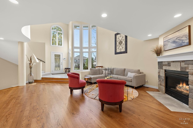 living room with light wood-type flooring, a wealth of natural light, and a fireplace