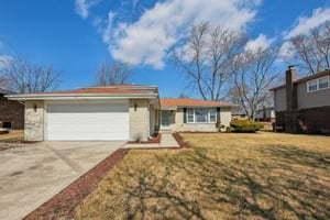 ranch-style home featuring concrete driveway and an attached garage