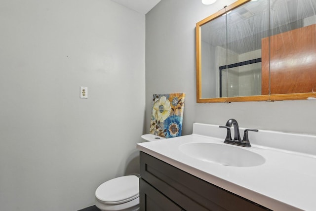 bathroom with a shower with shower door, toilet, and vanity